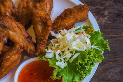 Fried chicken wings with vegetable on white plate delicious food still life.