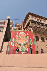 Low angle view of statue against building against sky