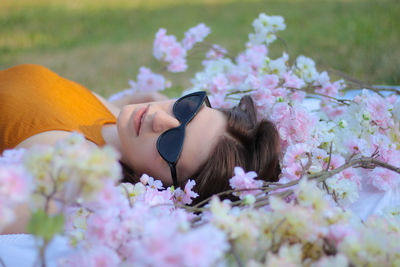Woman lying on pink flowering plants