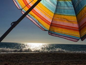 Low angle view of beach against sky during sunset