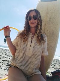 Young woman wearing sunglasses sitting on beach