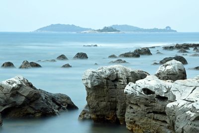 Scenic view of rocks in sea against sky