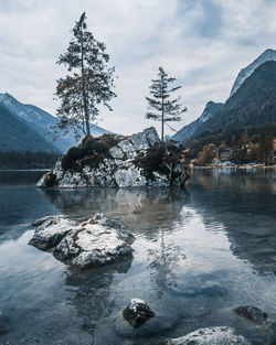 Scenic view of lake by snowcapped mountains against sky