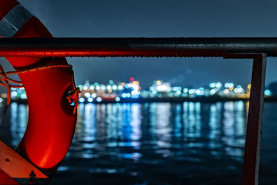 Close-up of railing by river at night