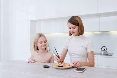 Portrait of young woman using mobile phone at home