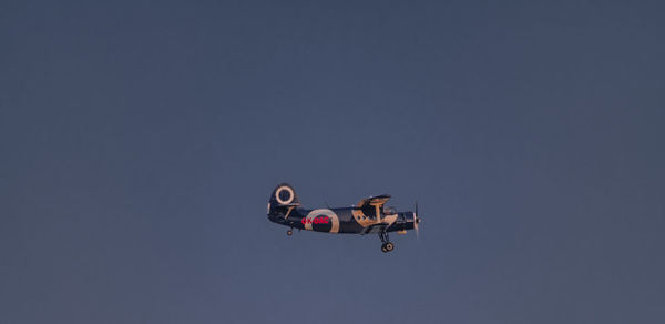 Low angle view of airplane flying against clear sky