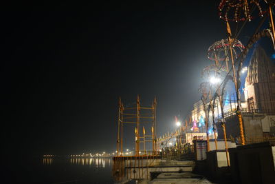 Low angle view of temple by river against sky at night