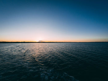 Scenic view of sea against clear sky during sunset