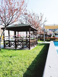 Gazebo in park by building against sky