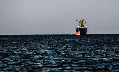 Lighthouse sailing on sea against clear sky