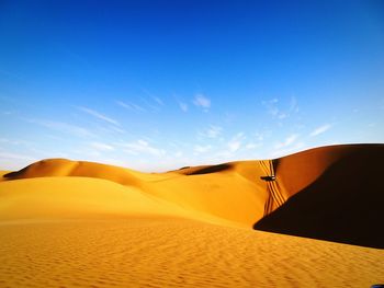 Scenic view of desert against clear blue sky