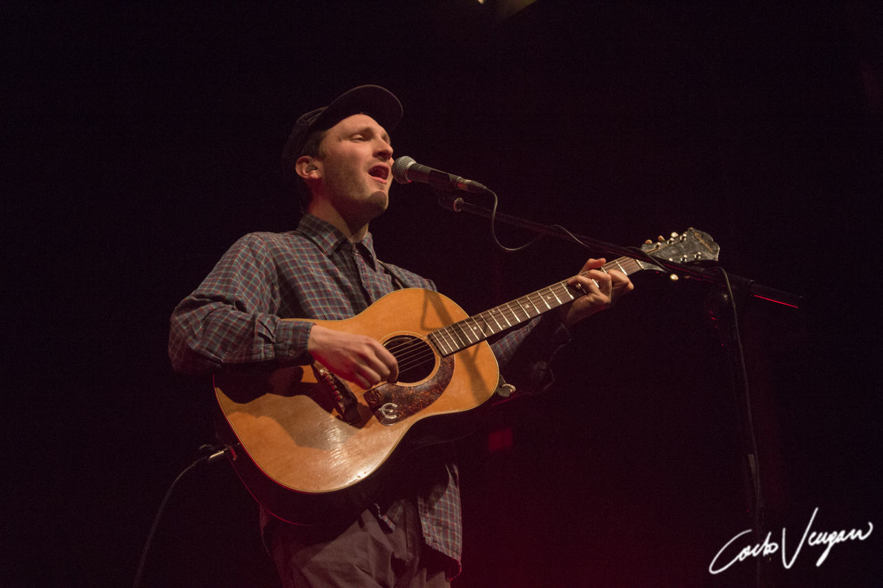 music, musical instrument, arts culture and entertainment, musician, musical equipment, playing, performance, one person, string instrument, artist, guitar, microphone, young men, input device, three quarter length, holding, skill, indoors, men, real people, plucking an instrument, stage, acoustic guitar, black background, nightlife