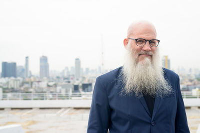 Portrait of man standing against cityscape