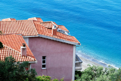 High angle view of building by sea against blue sky