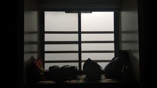 People relaxing in glass window at home