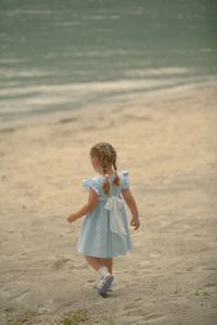 Rear view of woman walking on beach