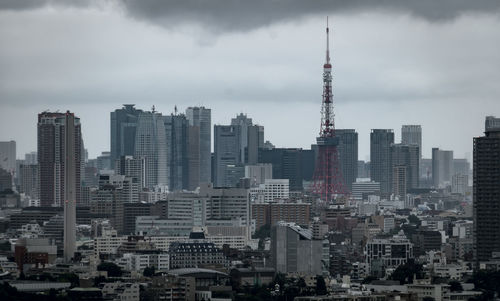 Buildings in city against cloudy sky