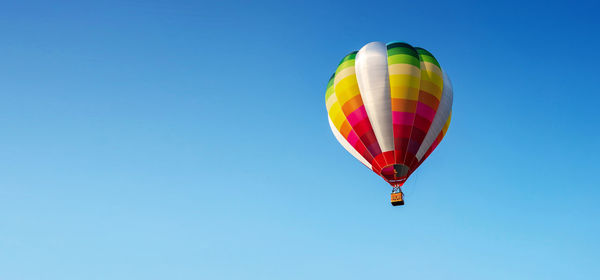 Low angle view of hot air balloon against clear blue sky