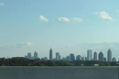 City at waterfront against cloudy sky