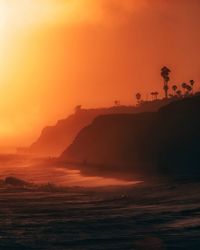 Scenic view of sea against orange sky