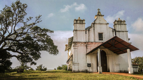 Low angle view of trees and buildings against sky