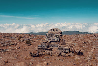 Text on rock against sky