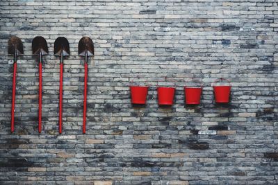 Shovels and buckets mounted on stone wall