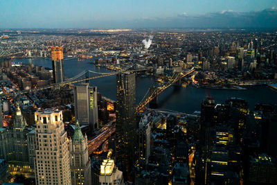 Illuminated cityscape against sky during sunset
