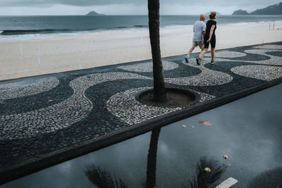 Rear view of couple standing at beach