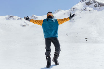 Full length of man standing on snowcapped mountain