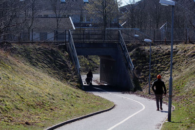 Rear view of riding man  on bridge