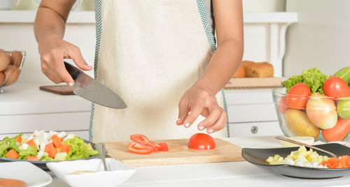 Midsection of man preparing food in kitchen at home