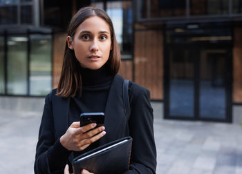 Portrait of young woman using mobile phone