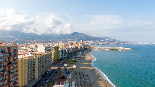 High angle view of cityscape by sea against sky