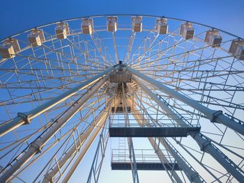 Low angle view of ferris wheel against clear blue sky