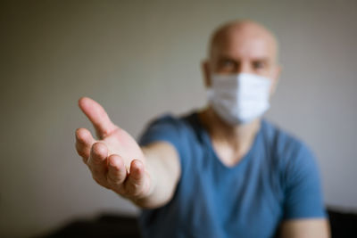 A man in a medical mask pulls his arms forward