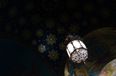 Low angle view of illuminated chandelier hanging in building