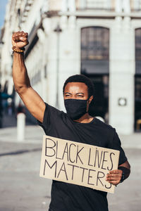 Man protesting at a rally for racial equality holding a poster against racism. black lives matter.