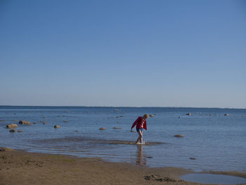 Woman on beach against clear sky