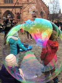 Full length of people on multi colored umbrella