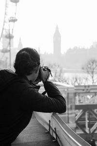 Rear view of man photographing through camera