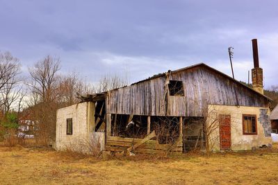 Abandoned building on field against sky