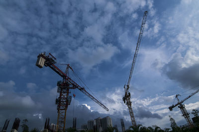 Low angle view of cranes against sky