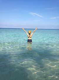 Low section of woman in sea against sky