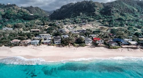 High angle view of houses by sea against mountains