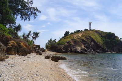 View of rocks on sea shore against sky