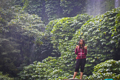 Full length of a woman standing in forest