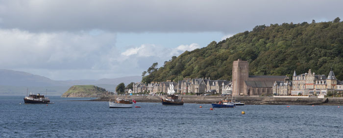 Boats sailing in sea against sky