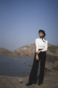 Full length of woman standing against sea and sky