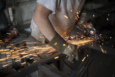 Work grinding machine. sparks from the force of friction. a man in a workshop processes metal. 